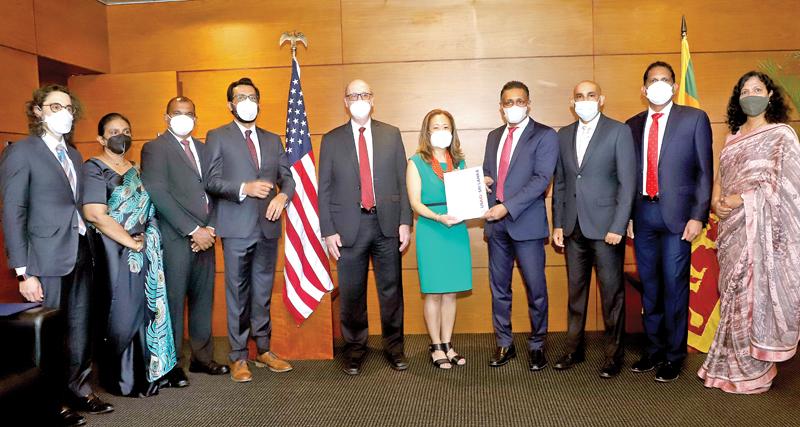 US Ambassador to Sri Lanka, Julie Chung (sixth from left) presents the agreement to Director and CEO, DFCC Bank, Thimal Perera (seventh from left). DFCC and USAID officials look on.