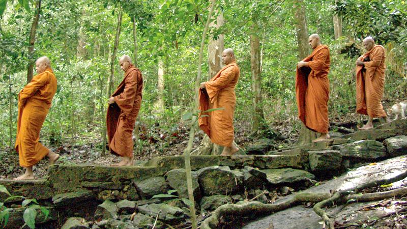 The meditative bhikkhus walk in single file for pindapatha at Dombagaskanda hermitage in Ingiriya