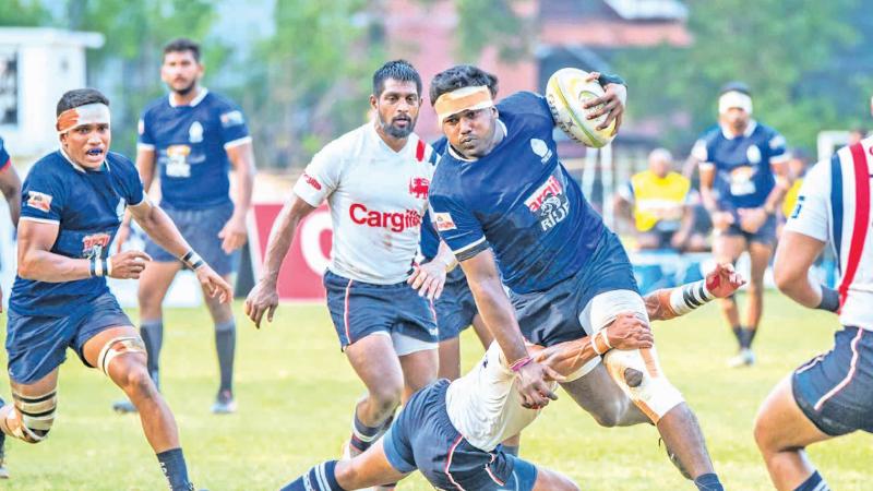 In this file photo before the Nippon Paint rugby league came to a sudden stoppage, Police SC prop and former Prince of Wales College captain Dimalka Thilakaratne attempts to break away from the Kandy SC defence