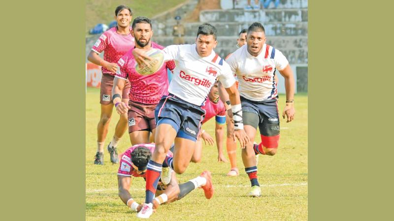 In this file photo Kandy SC skipper and fly-half Nigel Ratwatte breaks through a tackle from a Havelocks player during their first round match at Nittawela which they won