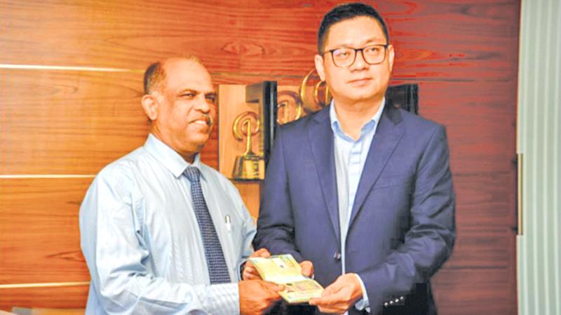 Controller of Immigration and Emigration Sarath Rupasiri presents the special visa to Baili Investments Director Chao Yin Man