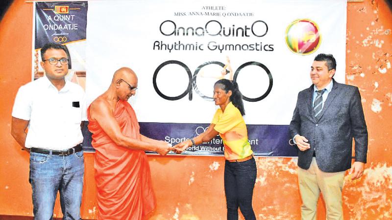 Headmaster of Sri Sangaraja Daham School Rev Dhemadusse Medhankara Thera presenting a cash donation to Paralympian Amara Indumathi Karunatilaka in the presence of Amal Edirisooriya (left) and Jeffrey Bahar (right)