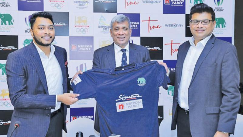 Amjad Marikkar (left) brand manager of Signature and Nimantha Abeysinghe (right) GM of Nippon Paint present the new jersey to Rizly Illyas (centre) president of Sri Lanka Rugby