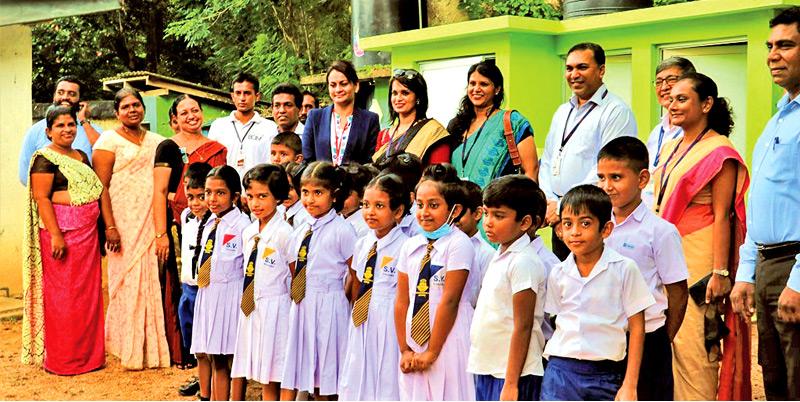 The Year Two students of Sumedha Maha Vidyalaya in Kosgama, stand proudly outside their brand-new toilet units, along with the school’s faculty members and AmCham, Teejay and Habitat Sri Lanka’s senior management staff