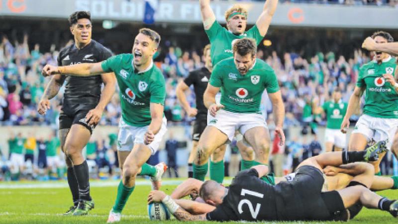 Ireland’s players (in green) react after scoring a try to beat New Zealand