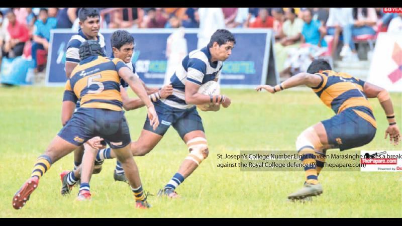 St. Joseph's College Number Eight Naveen Marasinghe makes a break against the Royal College defence (Pic: Thepapare.com)