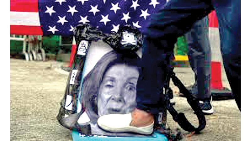 Pro-China supporters step on a picture of US House Speaker Nancy Pelosi during a protest outside the Consulate General of the United States in Hong Kong on August 3.