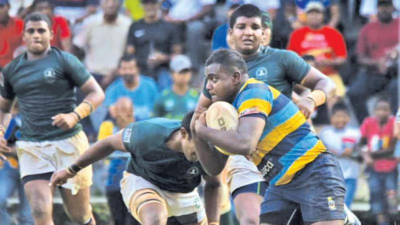 Vidyartha Number 8 Shirantha Dissanayake  attempts to break away from the Isipathana defence during play