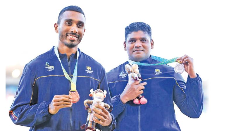 While Sri Lankan athletes and officials were exposing the country to disgrace and ridicule by decamping,100 metres sprinter Yupun Abeykoon (left) and Discuss thrower Palitha Bandara (right) kept the flag flying by winning Bronz and Silver respectively at the Commonwealth Games in Birmingham