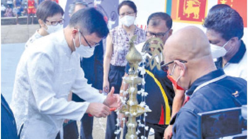 Lighting the traditional oil lamp by HE Ambassador Qi Zhenhong