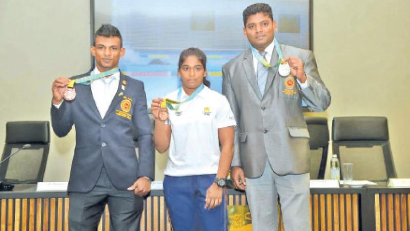 Medal winners (from left) Dilanka Kumara (weight lifting), Nethmi Fernando (wrestling) and Palitha Bandara (para athlete) pose with their medals