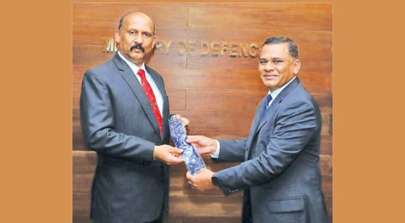 Sri Lanka Rugby (SLR) secretary Nizam Jamaldeen presents a rugby tie to former Army rugby promoter and current Defence Secretary retired General Kamal Gunaratne