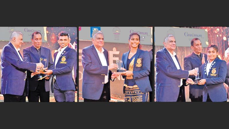 From left: Weightlifter Dilanka Isuru, netball captain Gayanjali Amarawansa and teenage wrestler Nethmi Fernando receive their awards from President Ranil Wickremasinghe at a felicitation ceremony held on Friday night at the Cinnamon Lakeside Hotel in Colombo