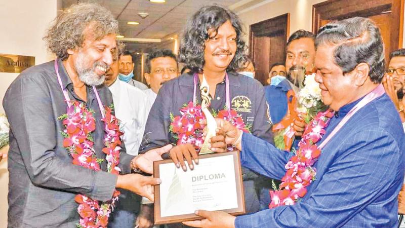 Media Minster Dr. Bandula Gunawardena  presents the award to the two Actors.