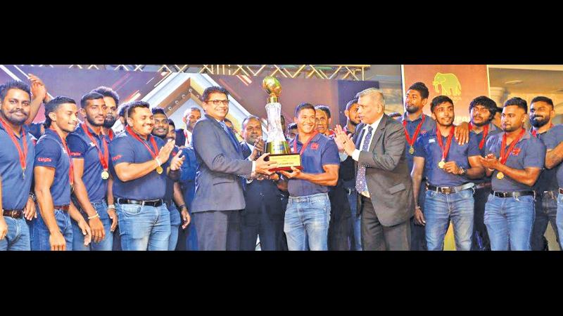 Nigel Ratwatte (right) the captain of the champion Kandy SC team holds aloft the Nippon Paint Trophy on behalf of his jubilant team-mates presented by Nemantha Abeysinghe the general manager of Nippon Paint in the presence of Sri Lanka Rugby president Rizly Illyas at last week’s awards ceremony held at the Kingsbury Hotel in Colombo (Pix by: Sulochana Gamage)