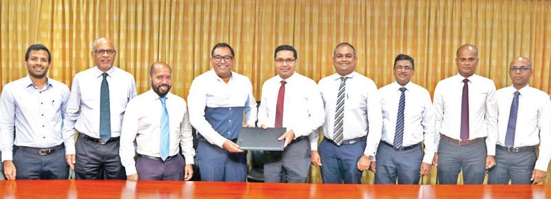 Commercial Bank Managing Director and CEO Sanath Manatunge (centre) and PAYable CEO and Co-Founder, Yohan Wijesiriwardane exchange the agreement. (From left): PAYable Directors Teresh Amaratunga and S. Shanmuganathan, PAYable General Manager   Saajid Reyaz, and Commercial Bank’s DGM Marketing Hasrath Munasinghe, Chief Manager, Card Centre Nishantha De Silva, Senior Manager, Card Centre Seevali Wickramasinghe and Officer Card Centre Wishan Fernando look on.