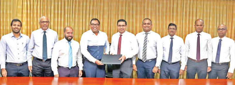 Commercial Bank Managing Director and CEO Sanath Manatunge (centre) and PAYable CEO and Co-Founder, Yohan Wijesiriwardane exchange the agreement. (From left): PAYable Directors Teresh Amaratunga and S. Shanmuganathan, PAYable General Manager Saajid Reyaz, and Commercial Bank’s DGM Marketing Hasrath Munasinghe, Chief Manager, Card Centre Nishantha De Silva, Senior Manager, Card Centre Seevali Wickramasinghe and Officer Card Centre Wishan Fernando look on.