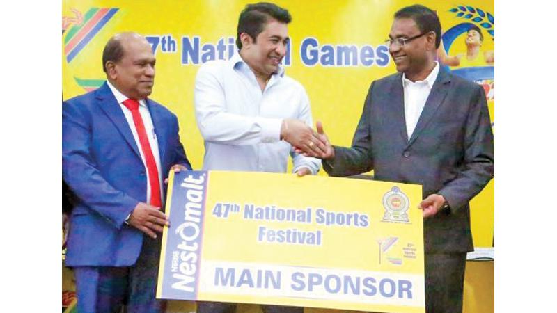 Bandula Egodage (right) vice president Corporate of Nestle presenting the sponsorship cheque to Roshan Ranasinghe (centre) Minister of Sports at the media briefing held at the Sports Ministry. Dr. Amal Harsha de Silva (left) Secretary to Ministry of Sport is also present