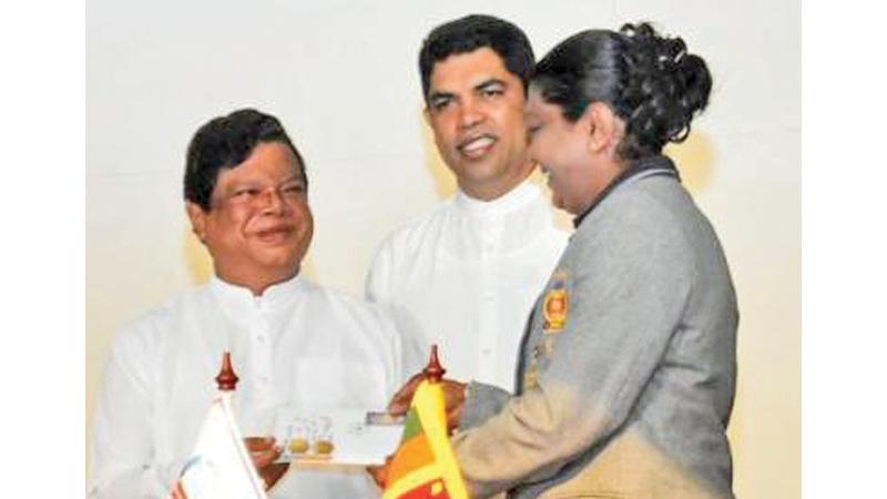 Olympic Silver Medalist Susanthika Jayasinghe receiving the Athletic Centenary Commemorative stamp First-Day cover from the Minister of Transport, Highways and Mass Media, Dr. Bandula Gunawardene at the Postal Headquarters Auditorium on Thursday (6) in the presence of State Minister of Mass Media Shantha Bandara