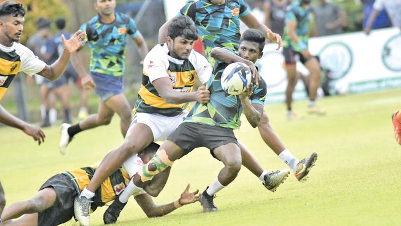 A player from the Sabaragamuwa Province team is tackled by a Western Province player on the first day of the Sri Lanka Sevens at the Race Course ground in Colombo yesterday