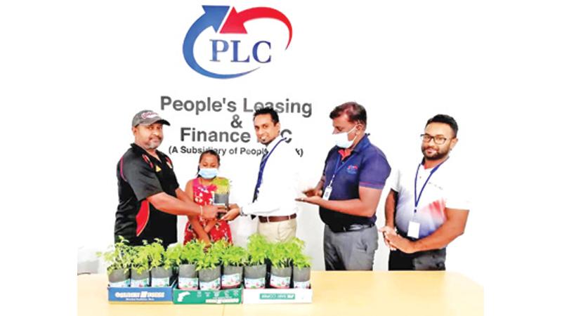 Manager of Tissamaharama Branch Maduka Nalin (centre), presents a chilli sapling to a customer and his daughter. Deputy Manager, Tissamaharama Branch, E.A.S. Lakminda, Cash Officer, Tissamaharama Branch Pradeep Chandrasena look on.