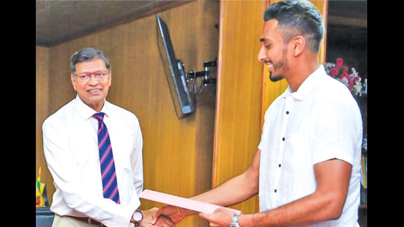 Yupun Abeykoon (right) shaking the hand of Mohan de Silva the secretary of Sri Lanka Cricket after receiving the purse
