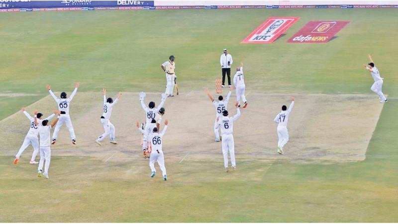 England fielders gather around the Pakistan pair as they closed in to win