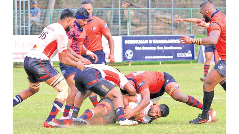 Kandy SC  fly-half Tharinda Ratwatte is brought down by CR’s forwards (Pic by Nissanka Wijerathne)