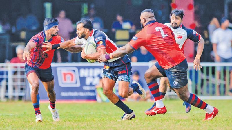 Kandy winger Kavindu Perera makes a break against opposition from CR’s Kavindu Costa (blue headband) and hooker Lahiru Pavithra  (Picture by - Nissanka Wijeratne)