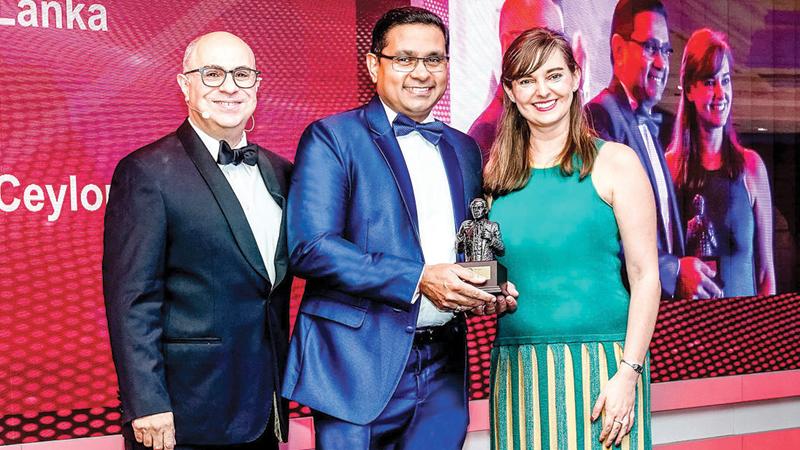 CEO Sanath Manatunge (centre) receives the award.