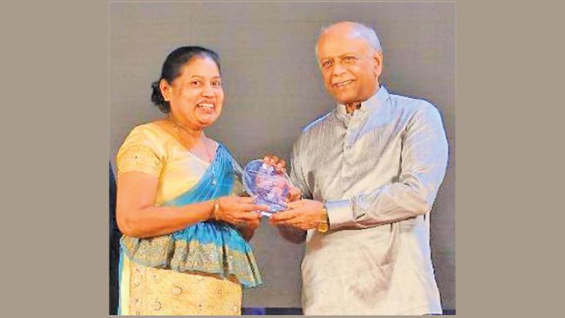 Suneetha Wijesuriya receives her award that was announced at the 44th Chess Olympiad in Chennai, India from Prime Minister Dinesh Gunawardena at Temple Trees in Colombo