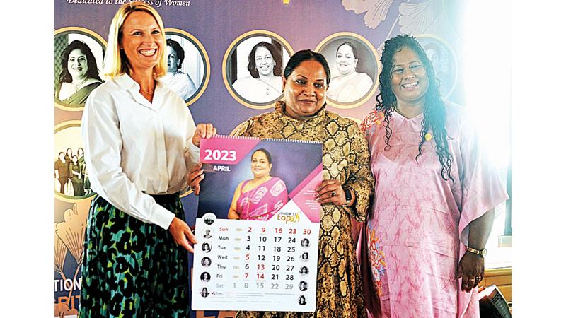 Program Manager, Women in Work Sri Lanka, IFC, Sara Twigg presents the calendar to President, WIM Canada Chapter, Julian Devika Anthony. WIM Chairperson Dr. Sulochana Segera looks on. Pic: Sudath Malaweera