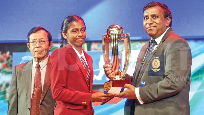 Chushadi Kaushalya receives the Most Popular School Girl Cricketer  award from Editor-in-Chief, Sunday Observer, Dinesh Weerawansa. Senior Associate Editor Dudley Jansz looks on. 