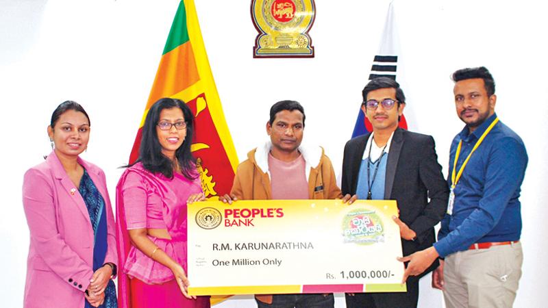 Ambassador of Sri Lanka to the Republic of Korea, Savitri Panabokke presents the cheque for Rs. 1 million to R.A. Karunarathna. Second Secretary of the Embassy, Sachini Dias, representative of the People’s Bank, Lahiru Alwis  and E9PAY Sri Lanka Manager, Tharuka Wijesinghe look on.