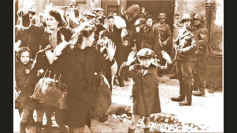 A group of Jewish civilians being held at gunpoint by German SS troops after being forced out of a bunker where they were sheltering during the Warsaw Ghetto uprising in German-occupied Poland,  World War II, April 19 - May 16, 1943