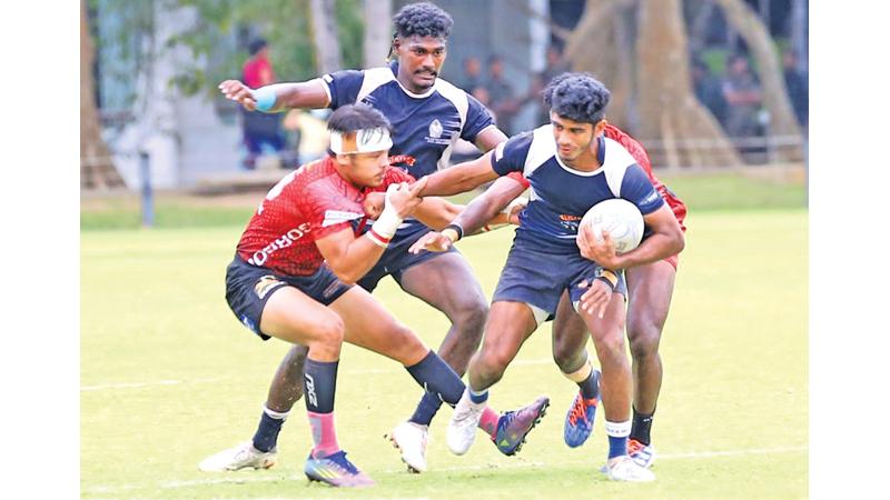 Police player Shane Hopwood is held by CH fullback Avantha Lee in their match on Friday at the Race Course ground. Police won 41-26  (Pic: Malan Karunaratne)