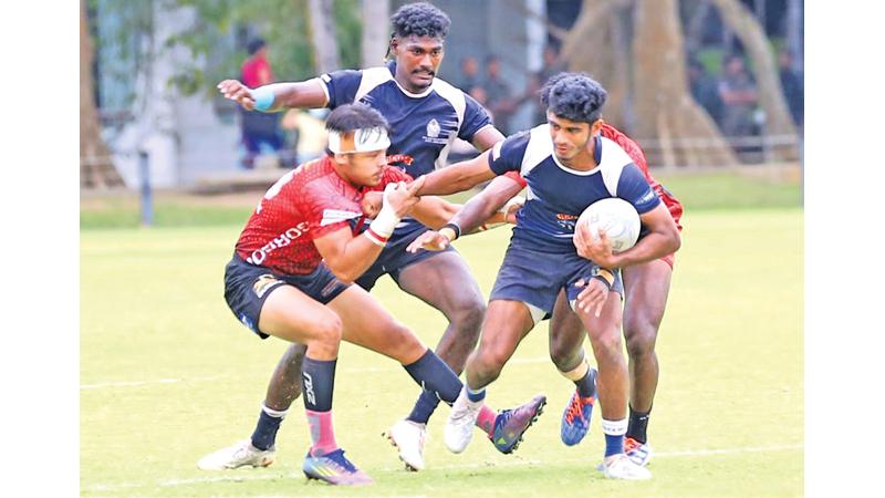 Police player Shane Hopwood is held by CH fullback Avantha Lee in their match on Friday at the Race Course ground. Police won 41-26 (Pic: Malan Karunaratne)