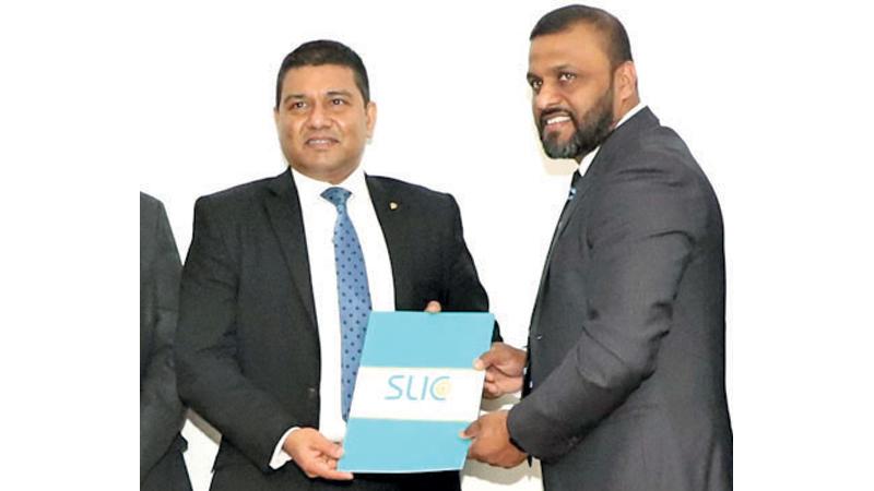 CEO, SLIC, Chandana L. Aluthgama exchanges the MoU with SLIM President Nuwan Gamage.