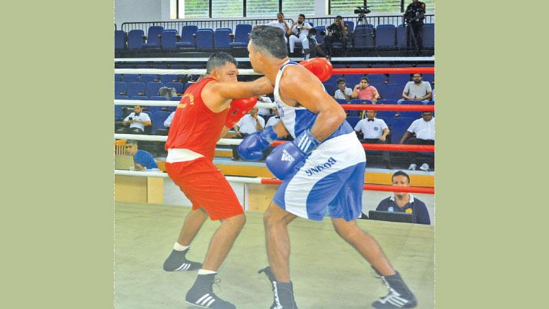 Action from the Light Heavyweight final between Police’s HWGP Rathnasiri (red) and Army’s WAMP Wariyapperuma at the finals of the Boxing Nationals at the Royal MAS Arena on Friday. (Pic by Sudath Nishantha)