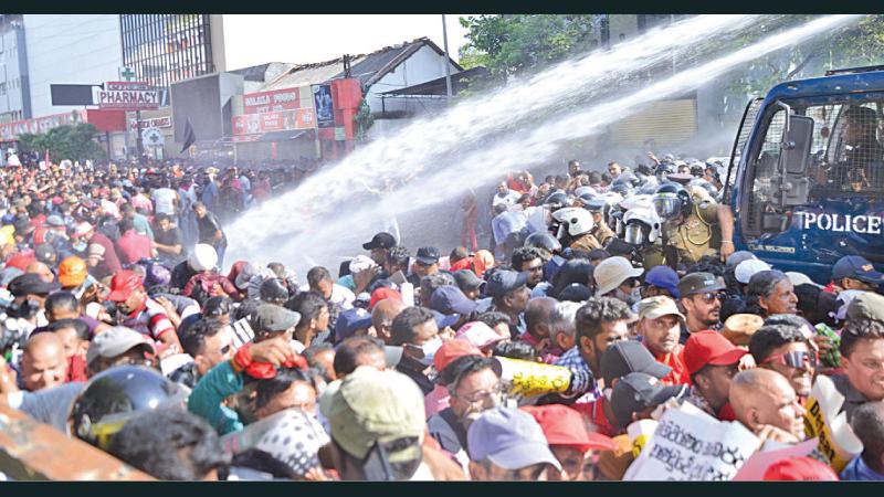 Police fired tear gas and used water cannons on the NPP protesters marchers heading towards Fort at Town Hall area yesterday. Picture by Shan Rupassara