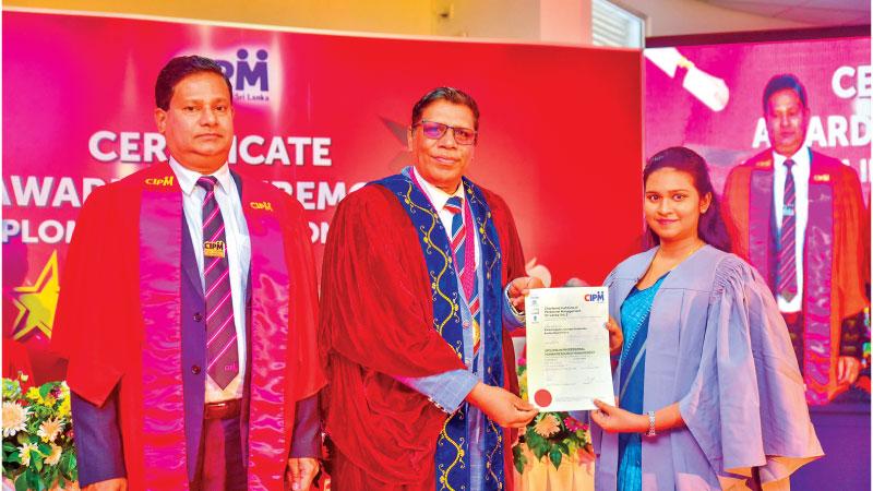 A diplomate receives the certificate from CIPM President Ken Vijayakumar. CIPM Vice President Priyantha Ranasinghe looks on.