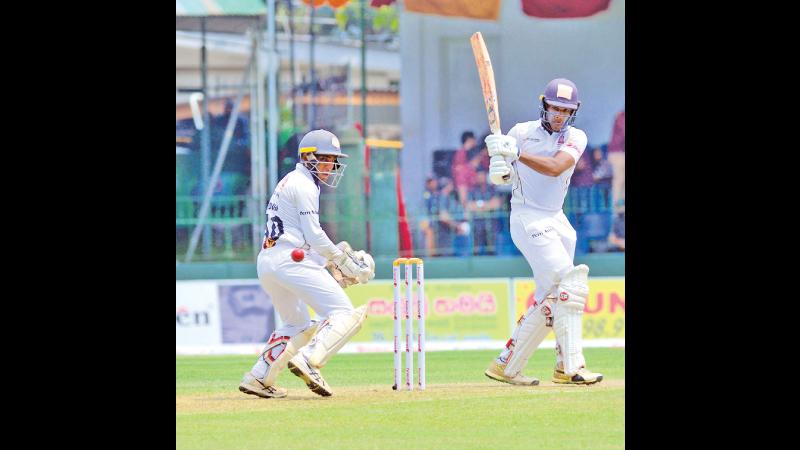 Nalanda College batsman Eranga Jayakody swings a ball towards fine-leg during his innings of 83 watched by wicket keeper Viduna Wijebandara on the first day of their 93rd Battle of the Maroons cricket encounter against Ananda College at the SSC ground in Colombo yesterday (Pic by Chinthaka Kumarasinghe)