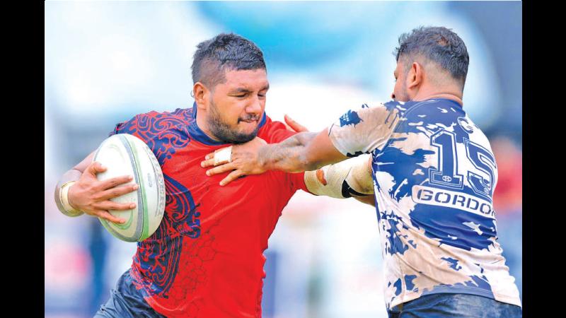 CR’s playmaker and centre Chathura Seneviratne unleashes a hand-off on Navy defender Thilina Weerasinghe during their League match in the run-up to the Clifford Cup