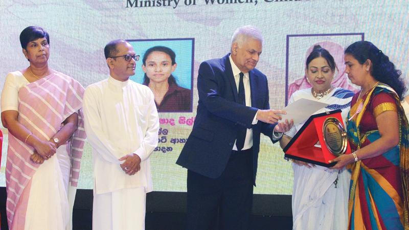 Emmanuel Easwaran of Jaffna district who markets food in glass bottles is honoured by President Ranil Wickremesinghe. State Minister of Women and Child Affairs Geetha Kumarasinghe look on. Pic: Sudath Nishantha