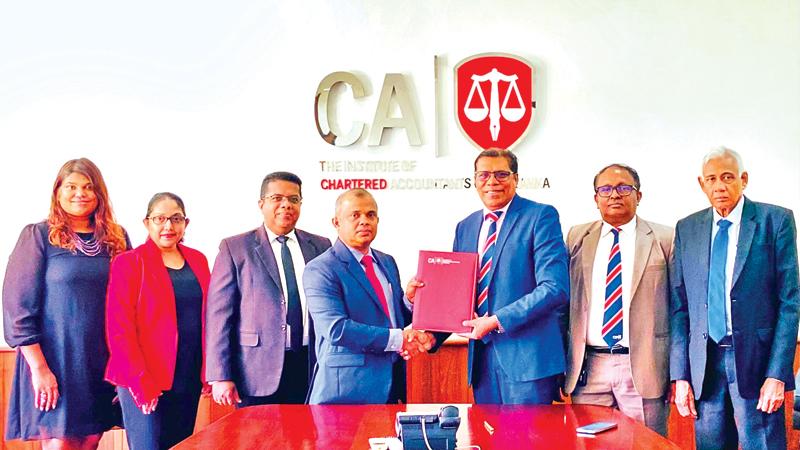 President of CA Sri Lanka, Sanjaya Bandara (on left) exchanges the MoU with President of CIPM Sri Lanka. Ken Vijayakumar. Senior officials of CIPM and CA Sri Lanka look on.