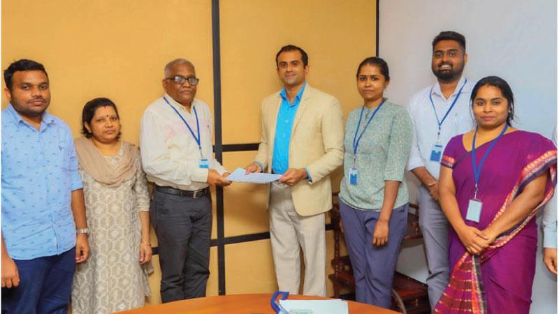  Chairman Lankaila Dhakshitha Bogollagama exchanges the agreement with members of the Balaji Ocean Hotel, Arugam Bay in a commercial bank in Colombo.  Pic: Sulochana Gamage