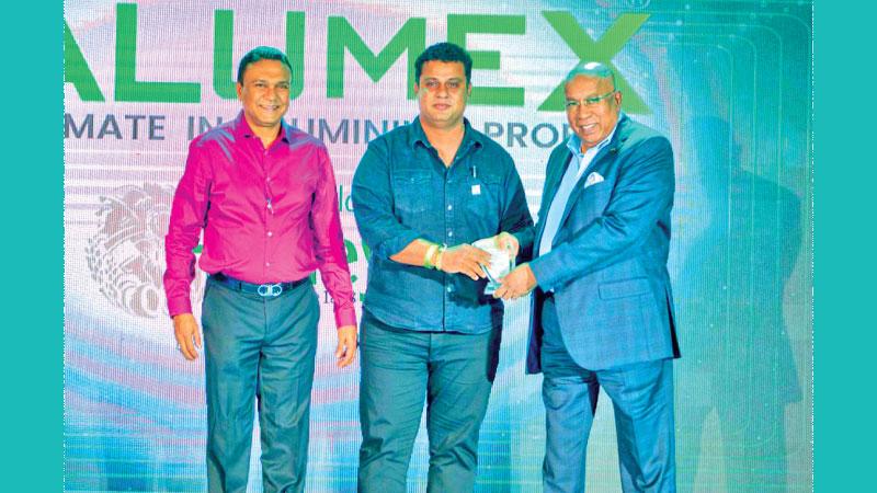 Hayleys Group Chairman and Chief Executive Mohan Pandithage (right) presents a token of appreciation to an aluminium fabricator. Alumex Managing Director Pramuk Dediwela looks on.  