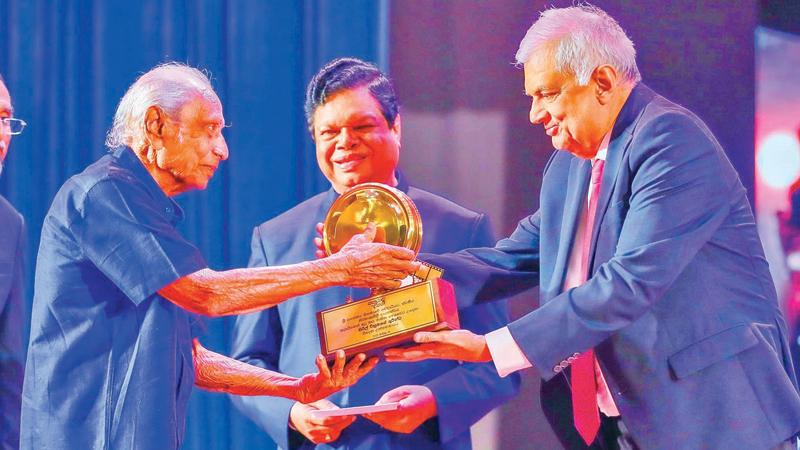 President Ranil Wickremesinghe presenting the award  to veteran actor Cyril Wickramage