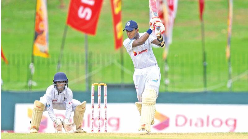 St. Joseph’s College captain Sadeesh Jayawardena drives a ball on his way to a century as St. Peter’s College wicket keeper Nathan David looks on