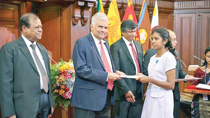 President Ranil Wickremesinghe presents a scholarship to a GCE O/L top performer at the Presidential Secretariat. Pic: Courtesy PMD